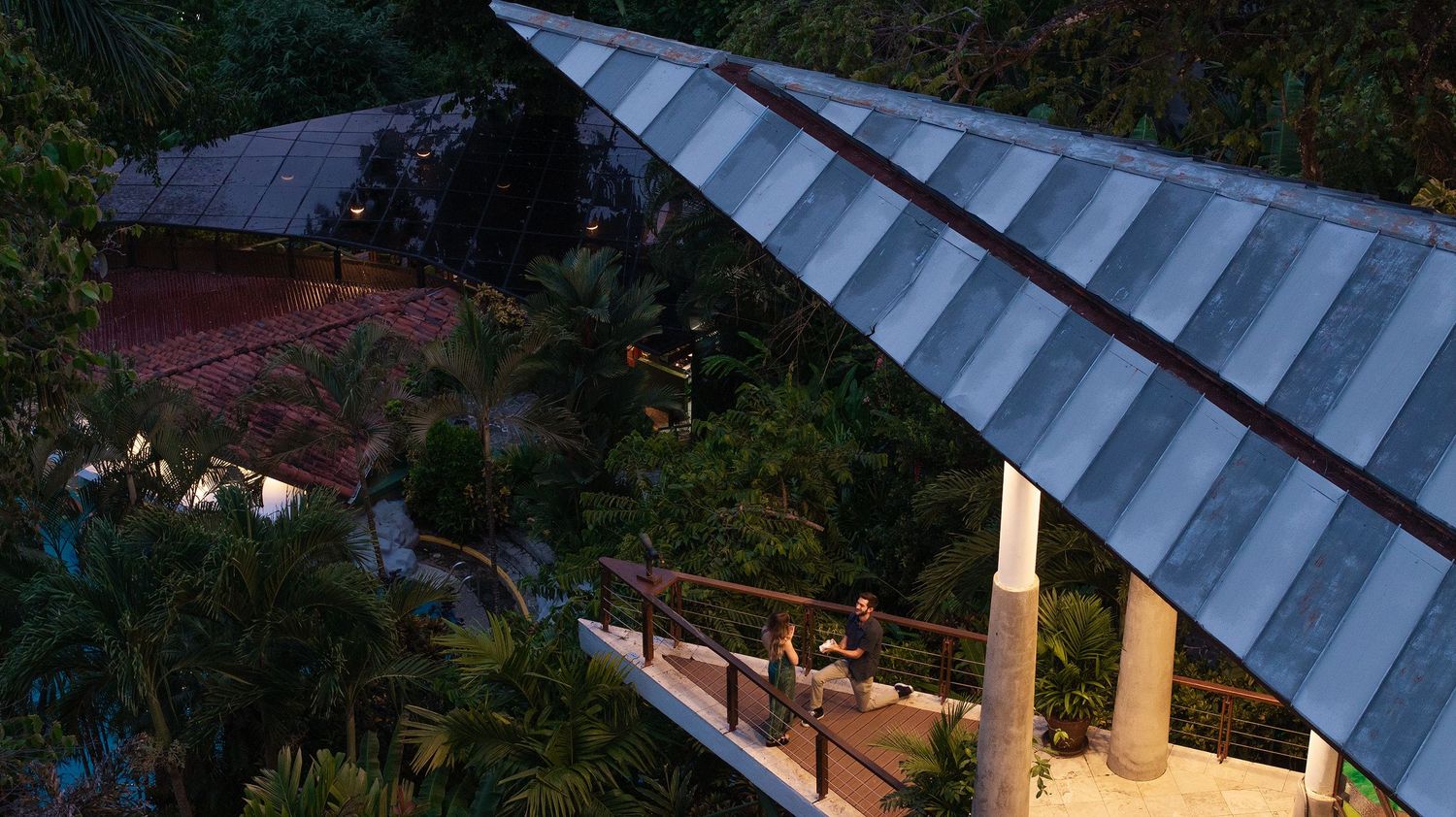 Scenic view of cabins nestled under blue metal roofs surrounded by lush greenery.