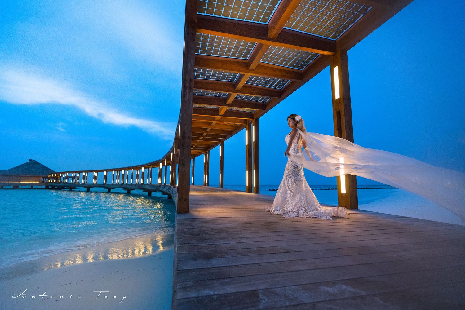 Elegant bridal portrait on oceanfront boardwalk at dusk with flowing veil and turquoise waters. Weeding, Malvides