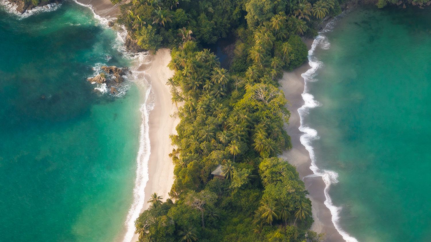 Aerial view of turquoise coastline with pristine beaches and lush forest cliffs. Manuel Antonio, Costa Rica.