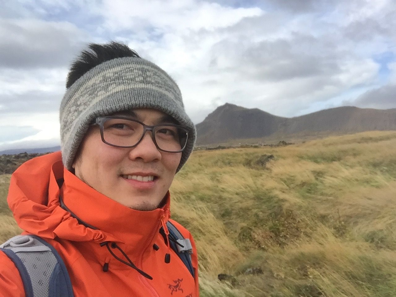 Scenic mountain landscape with grassy hills under cloudy skies captured in selfie style. Iceland.