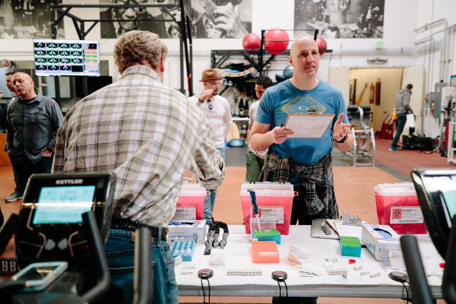 A merchandise table display setup at an event with electronic payment terminals and various items for sale.
