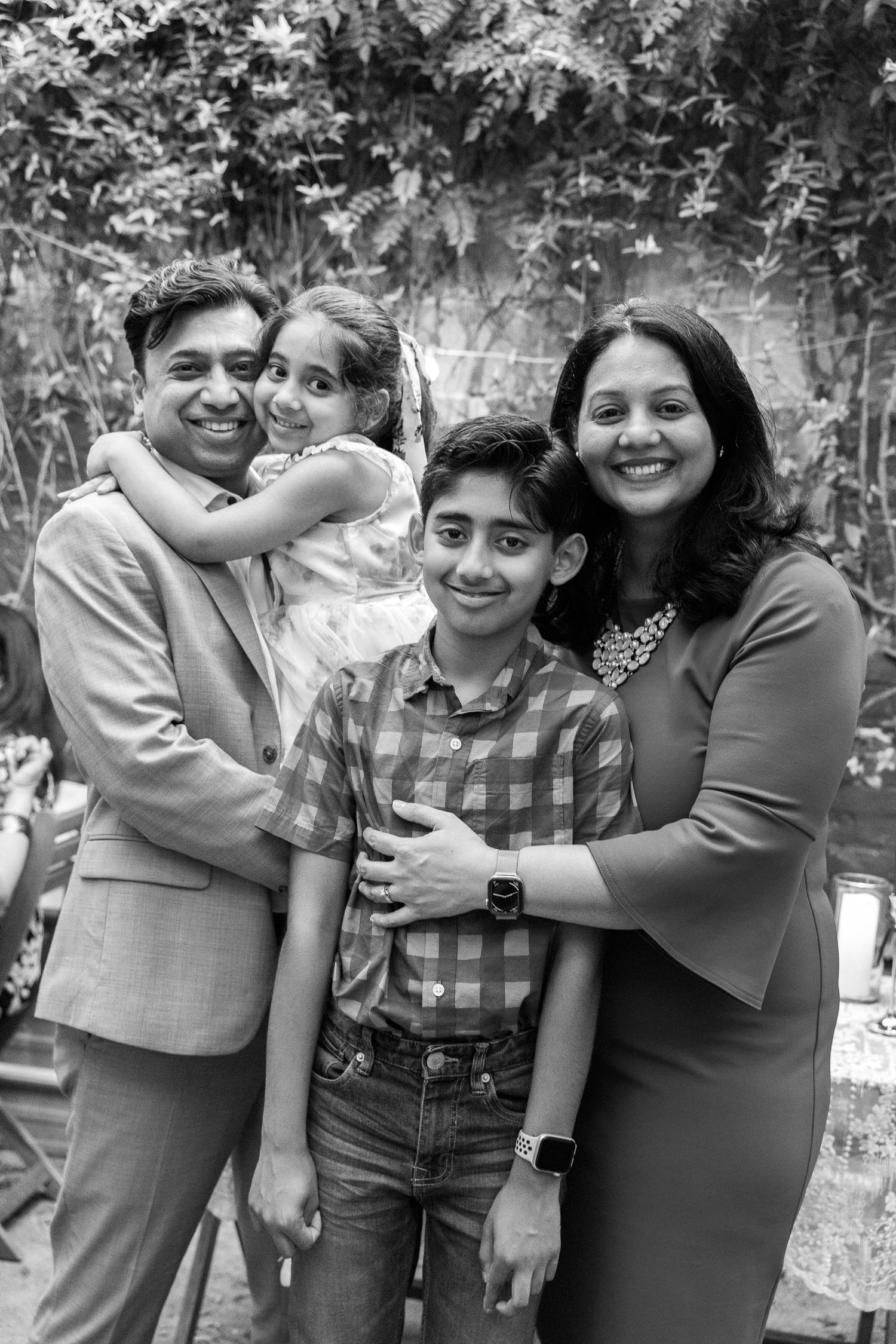 Black and white family portrait series showing joyful embraces and smiles.
