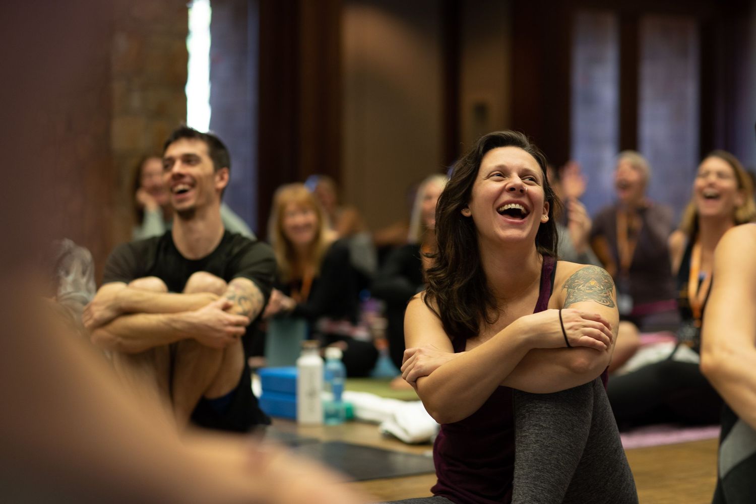 Workshop participants engaged in animated discussion in dimly lit indoor setting.