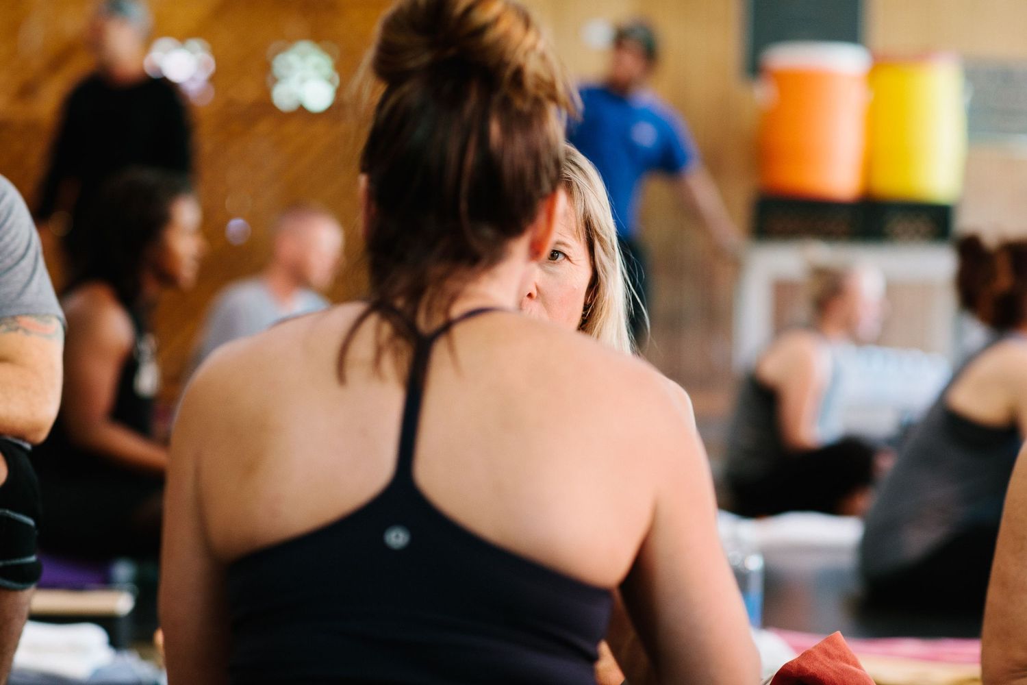 Back view of student in black tank top during yoga class session.