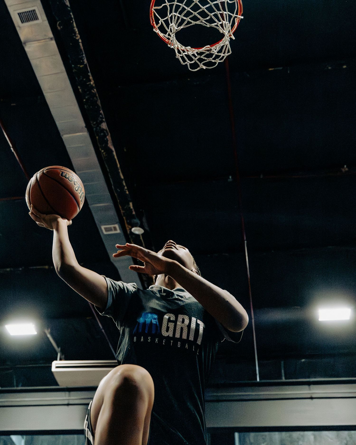 Close-up shot of basketball hoop and net during an indoor practice session.