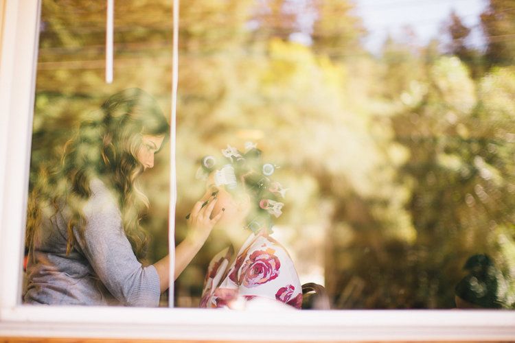 Soft-focus romantic moments captured through window panes with golden light.