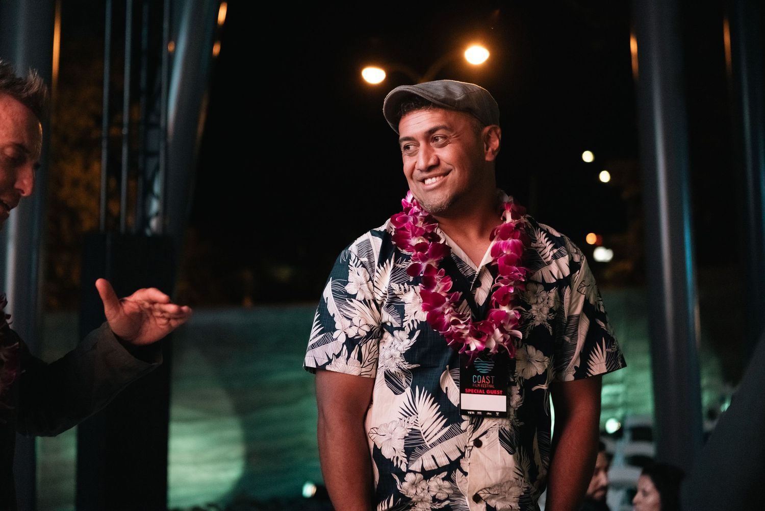 People enjoying a nighttime gathering with ambient lighting and tropical-themed attire.