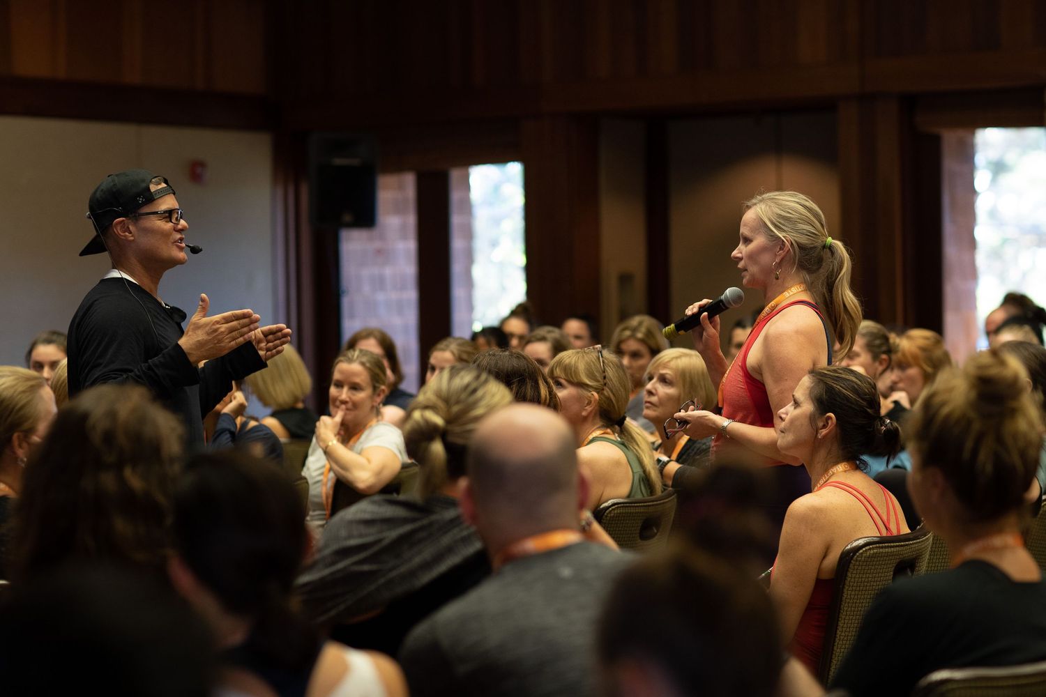 Workshop attendees engage with a speaker during an interactive fitness session in a conference hall.