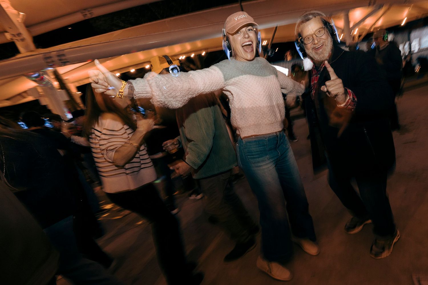 Crowd dancing and moving in synchronization at an indoor event space.