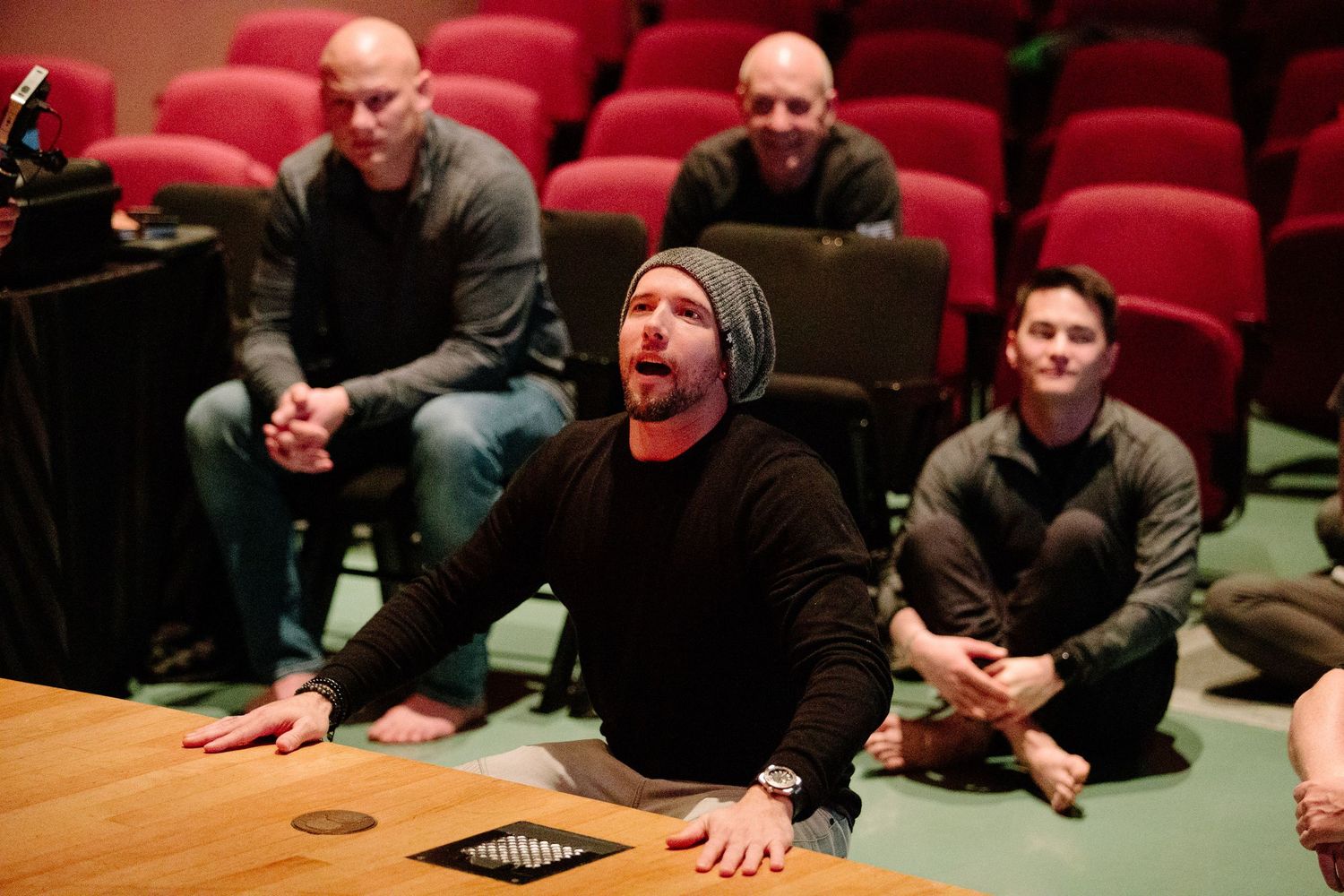 Workshop attendees showing emotional engagement during presentation in theater-style seating.