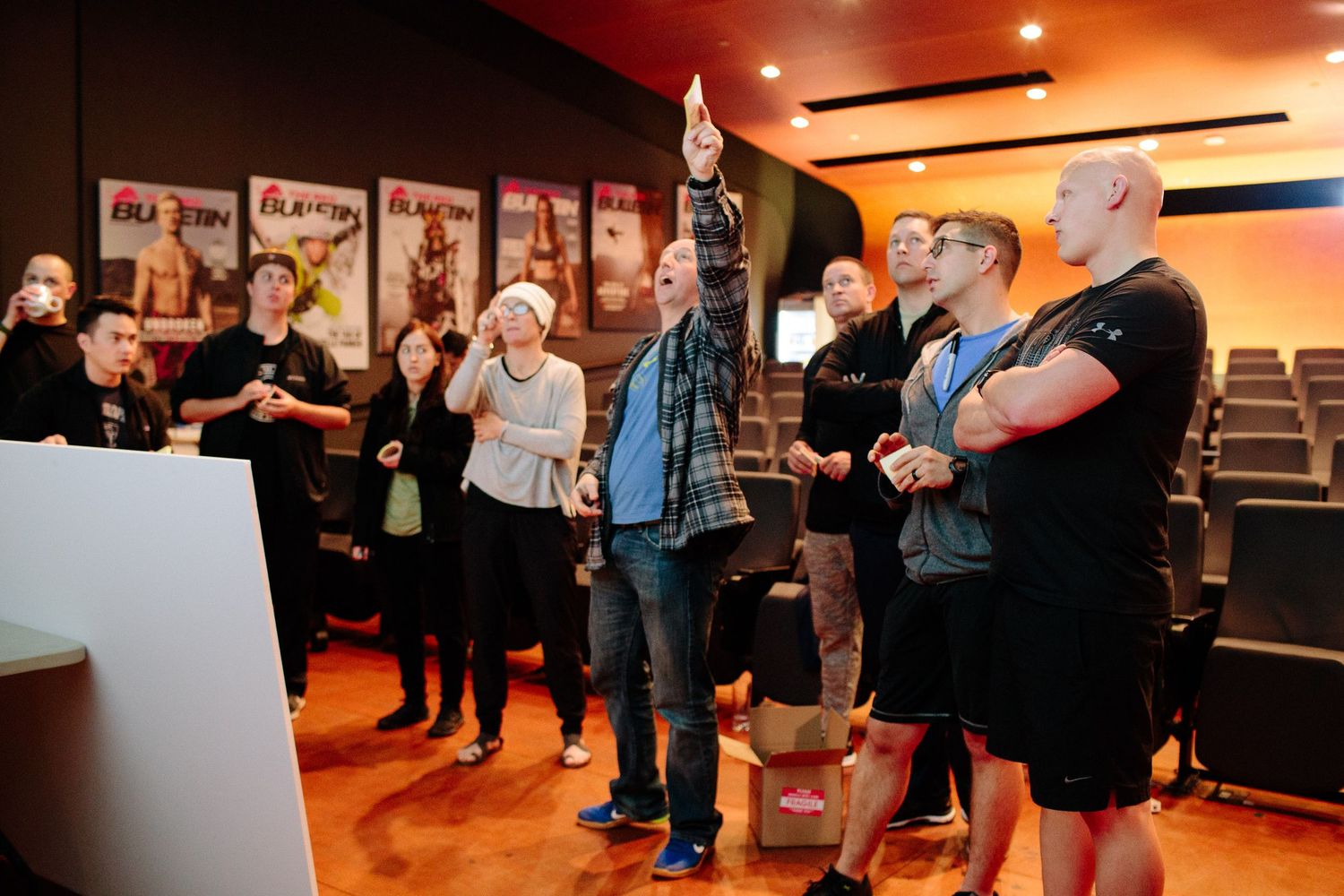 Group of people standing in a dimly lit room during an interactive workshop.