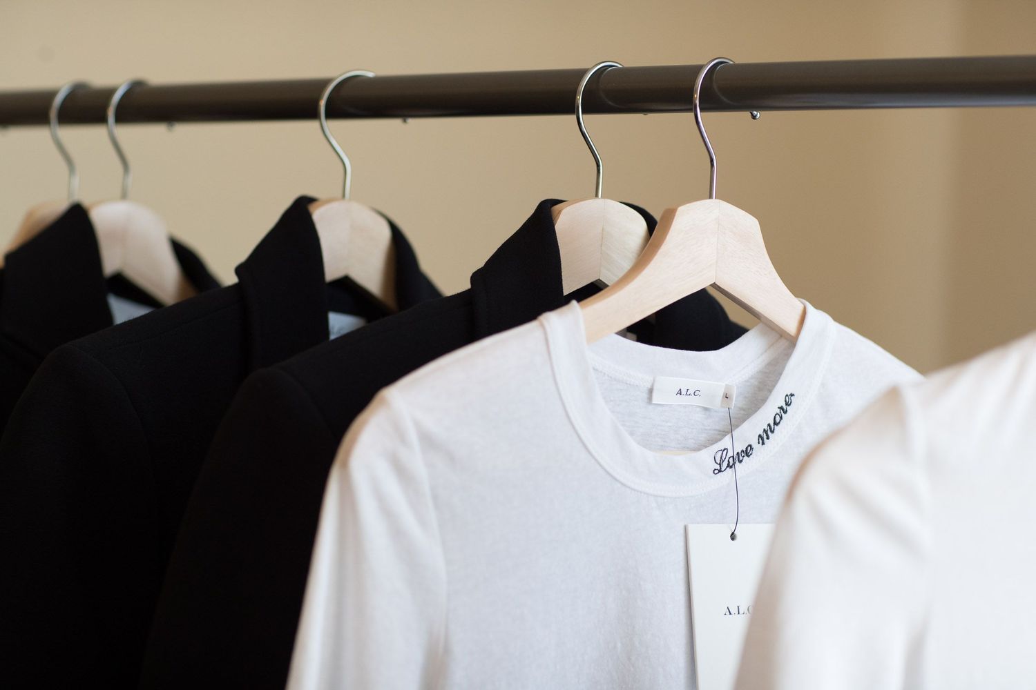 White collared shirts hanging neatly on retail display rack.