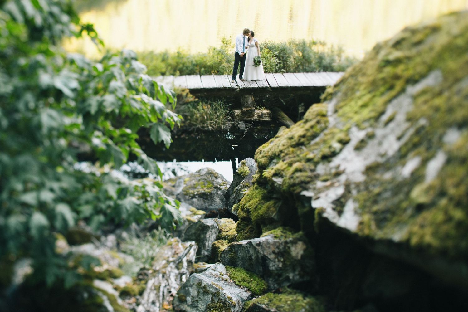Panoramic view of a dramatic cliffside wedding photoshoot with distant figures.