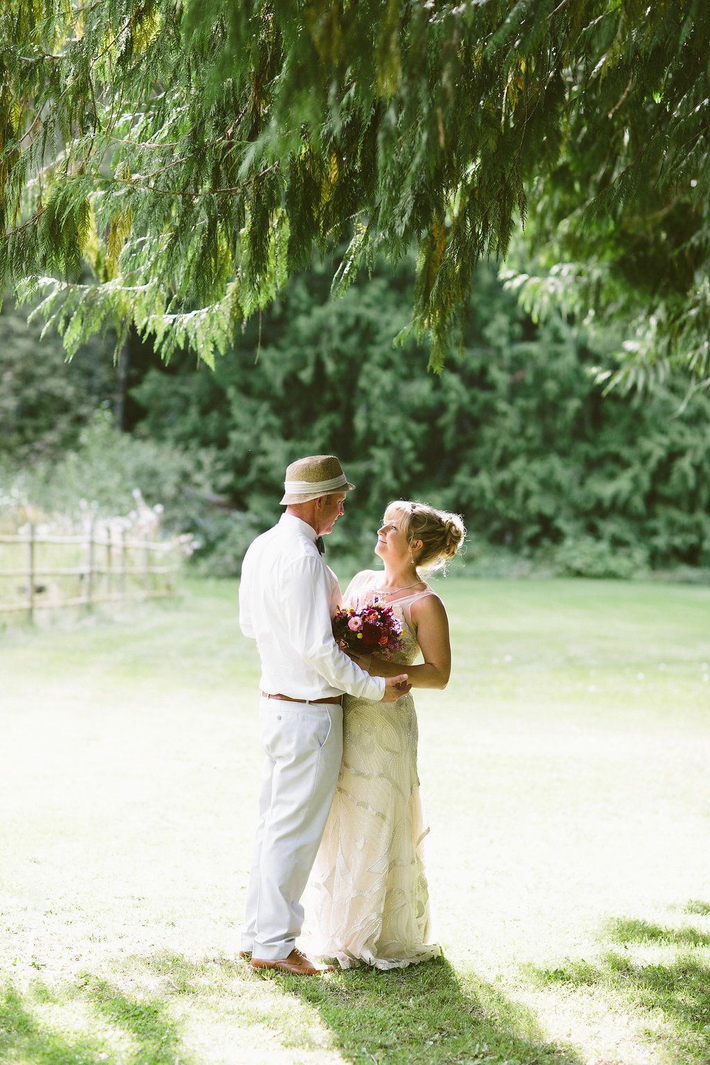 Romantic wedding couple moments under weeping willow trees in a garden setting.