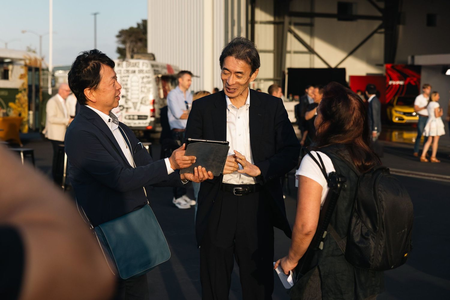 Candid shots of people networking and socializing at an outdoor evening event.