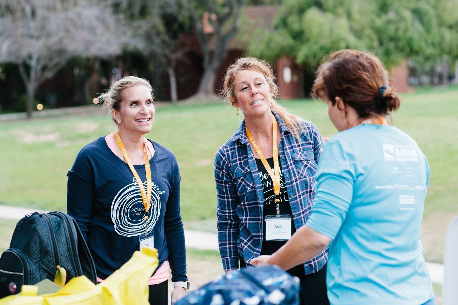 People interacting during an outdoor community gathering in a park setting.