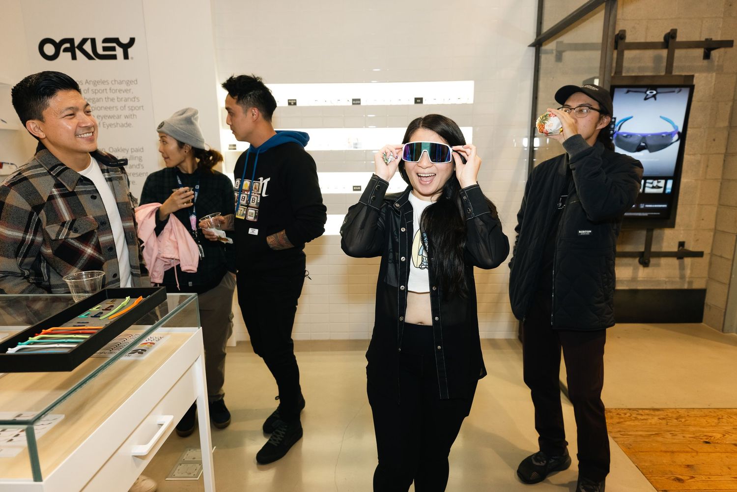 Customers trying on sunglasses at an Oakley retail store display for Oakley event