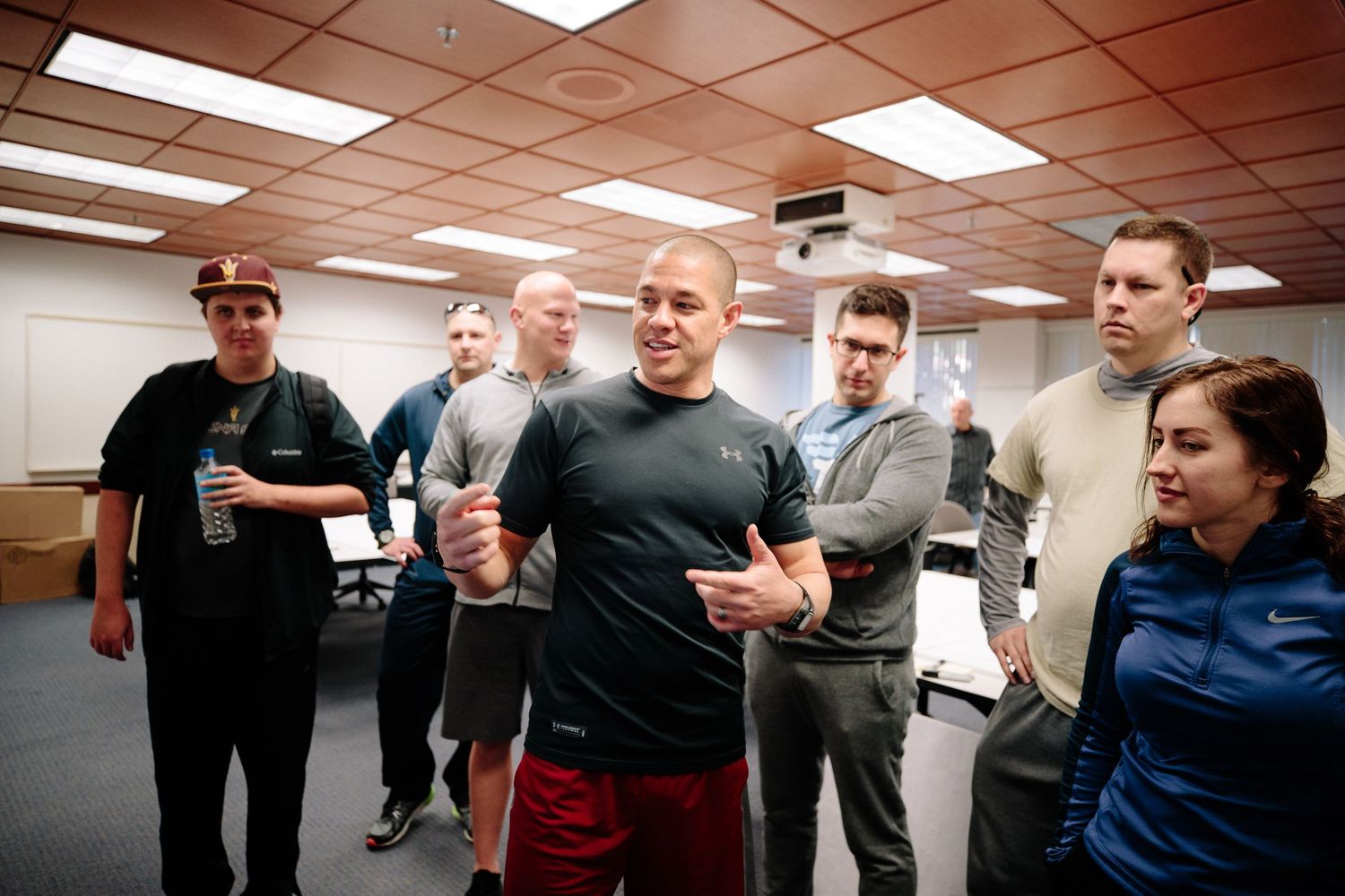 People participating in an indoor workshop or training session under fluorescent lights.