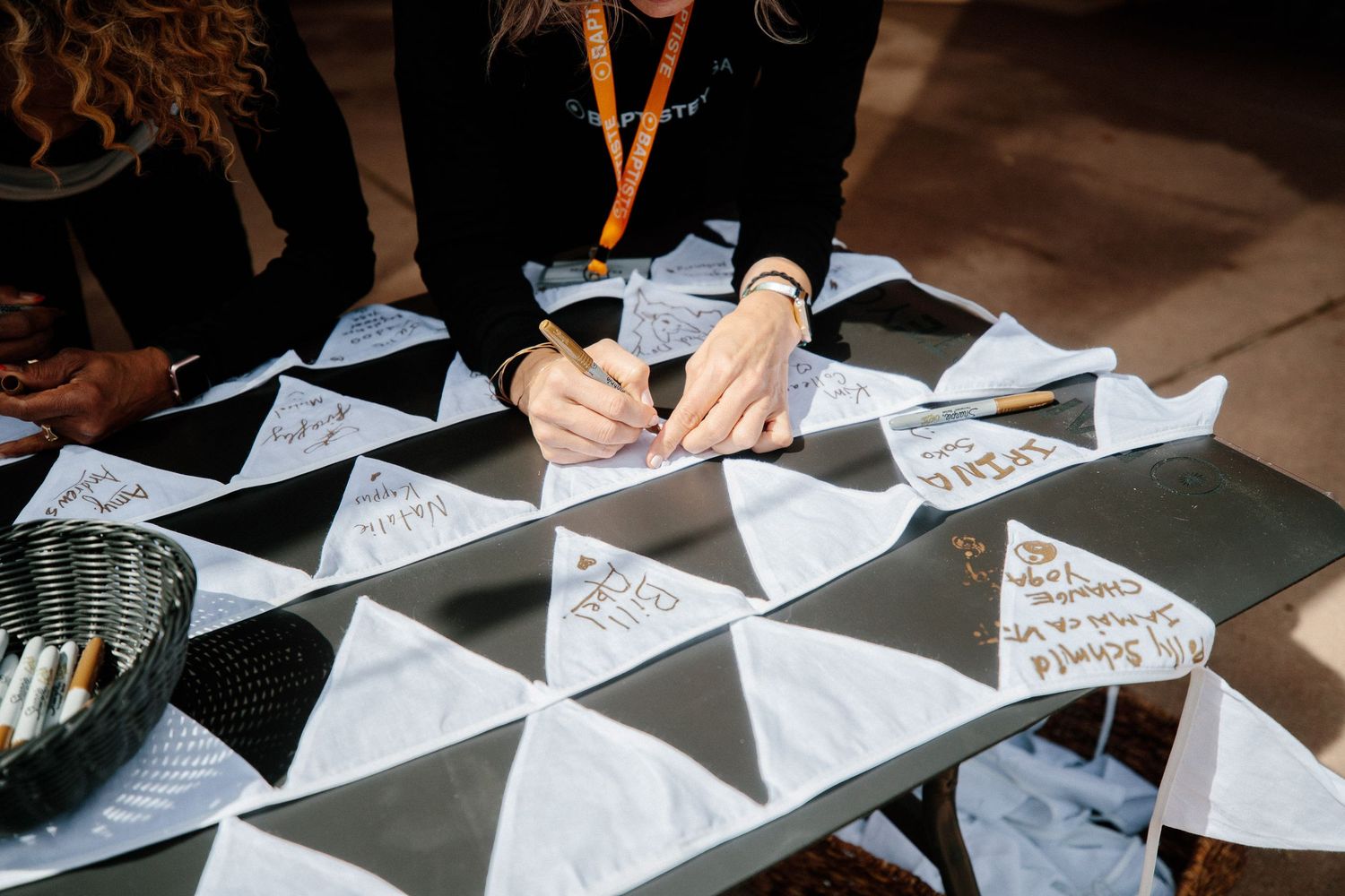 Hands writing on triangular papers arranged in a pattern.