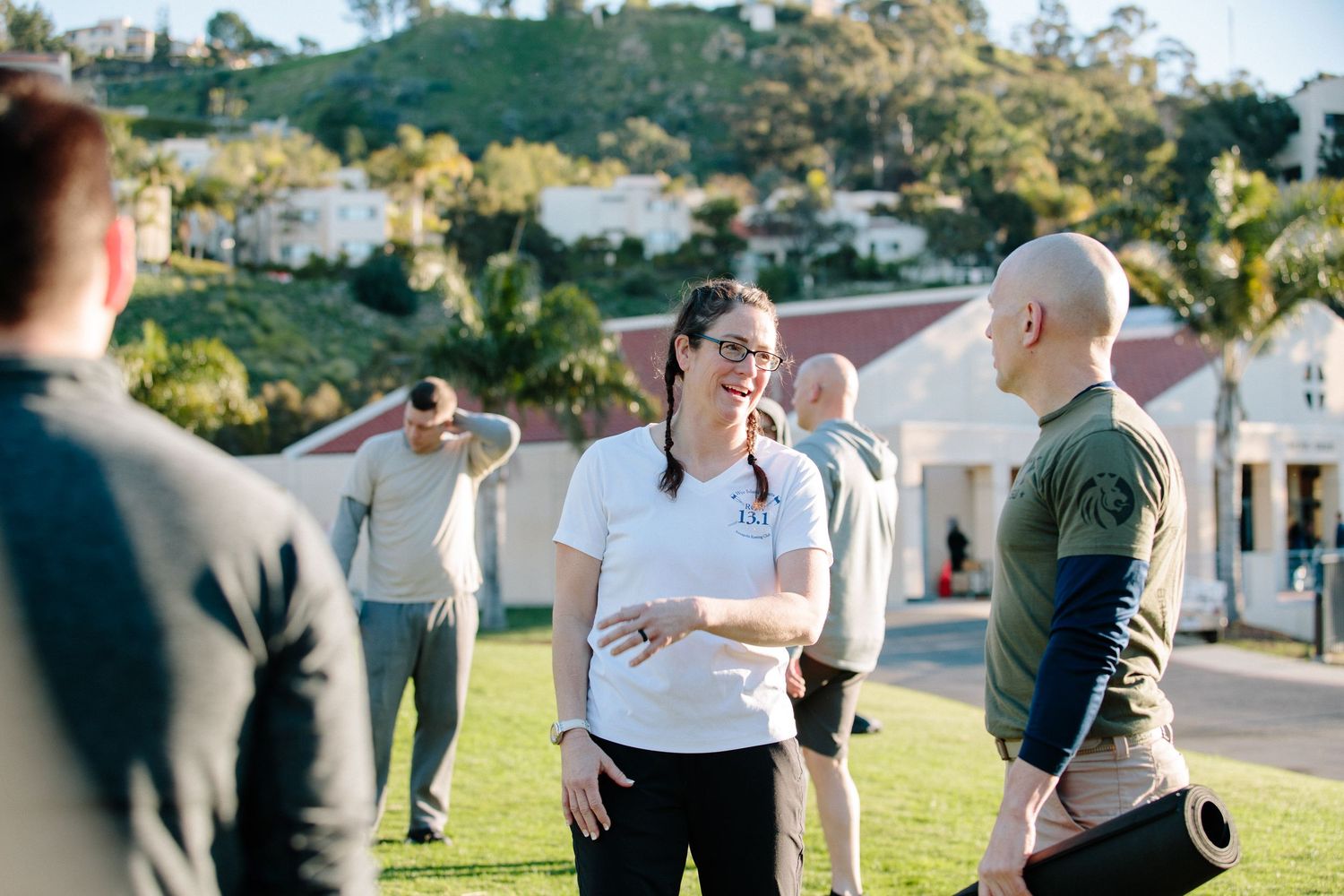 Interactive outdoor training session with participants engaged in discussion on sunny lawn.