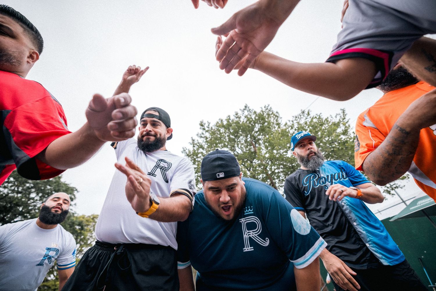 A group of people express excitement and joy during an outdoor gathering on a sunny day.