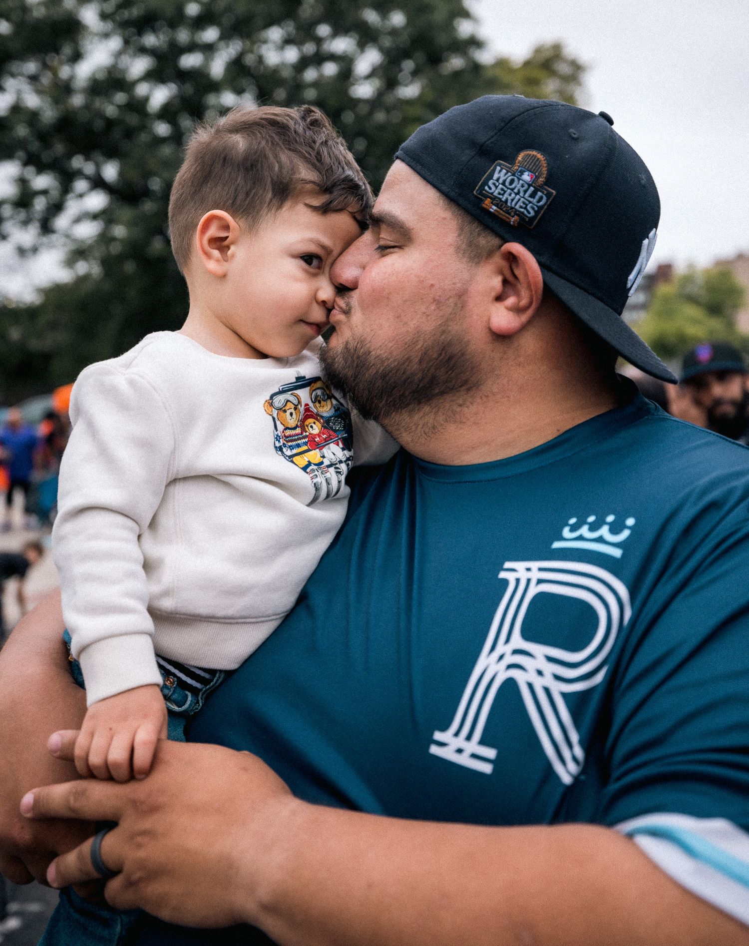 Tender moment between two people wearing casual clothes at an outdoor gathering.