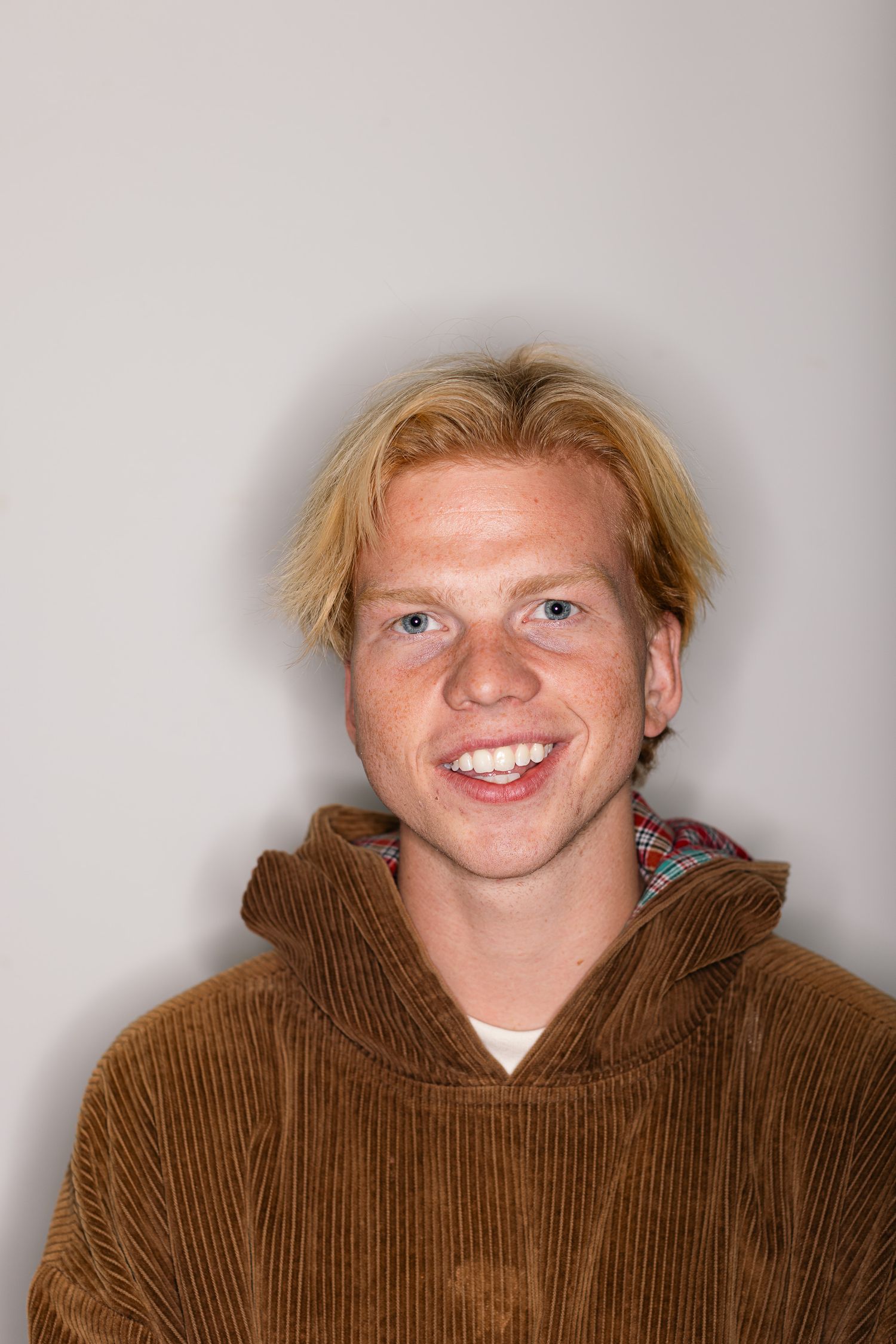 Portrait sequence showing expressions in a corduroy hoodie against a white background.