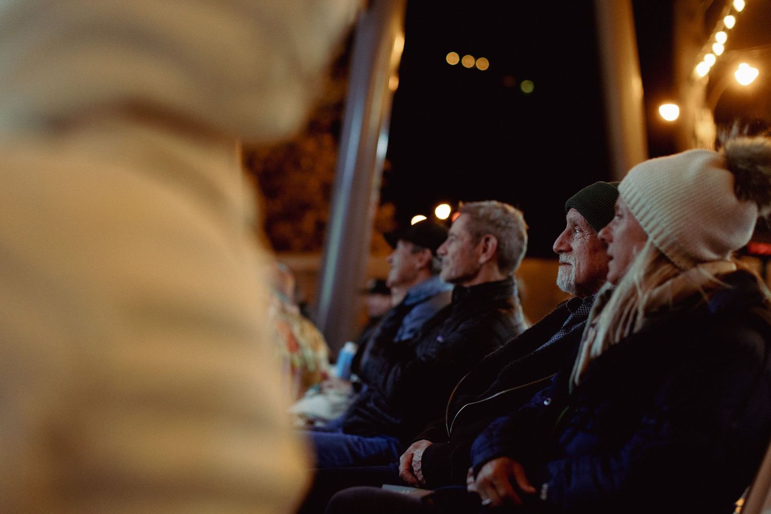 Dimly lit auditorium with audience members seated during an evening event.