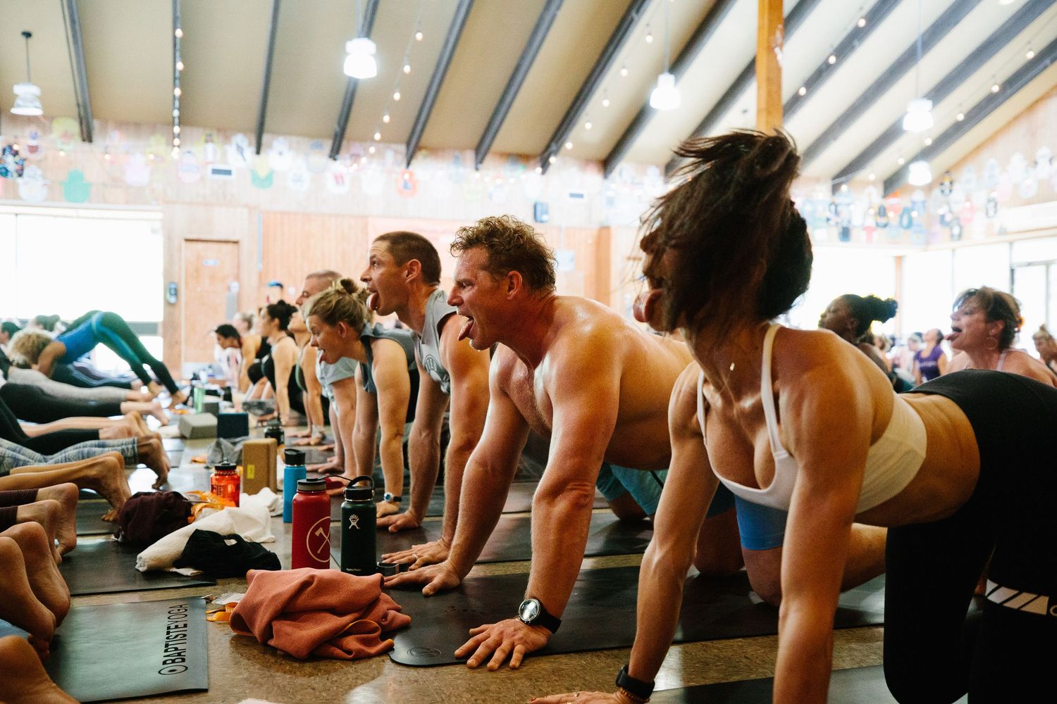 Fitness class participants in plank position during intense workout session.