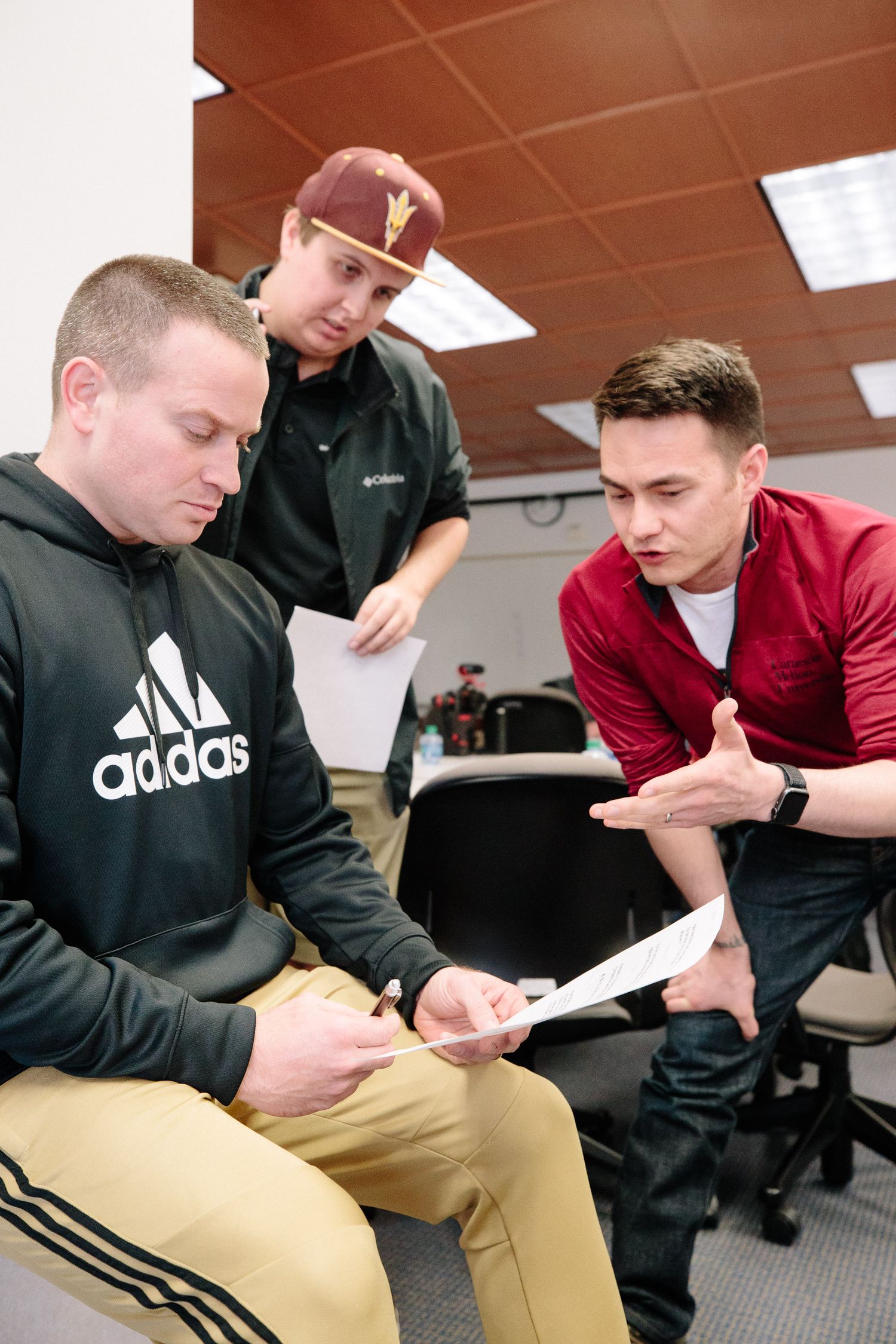 Students in casual attire studying materials during a classroom session.