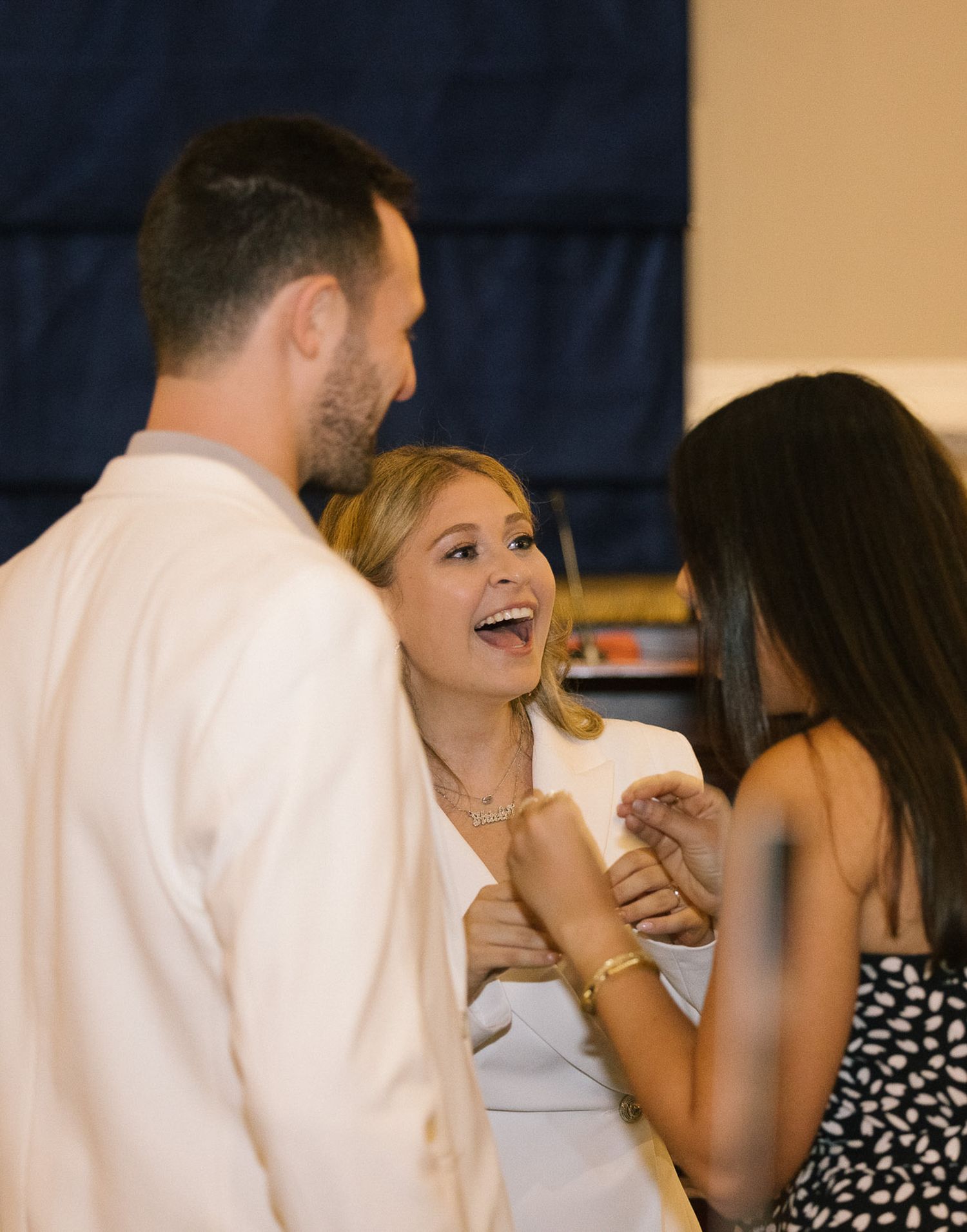 A lively conversation brings smiles and laughter at an indoor gathering.