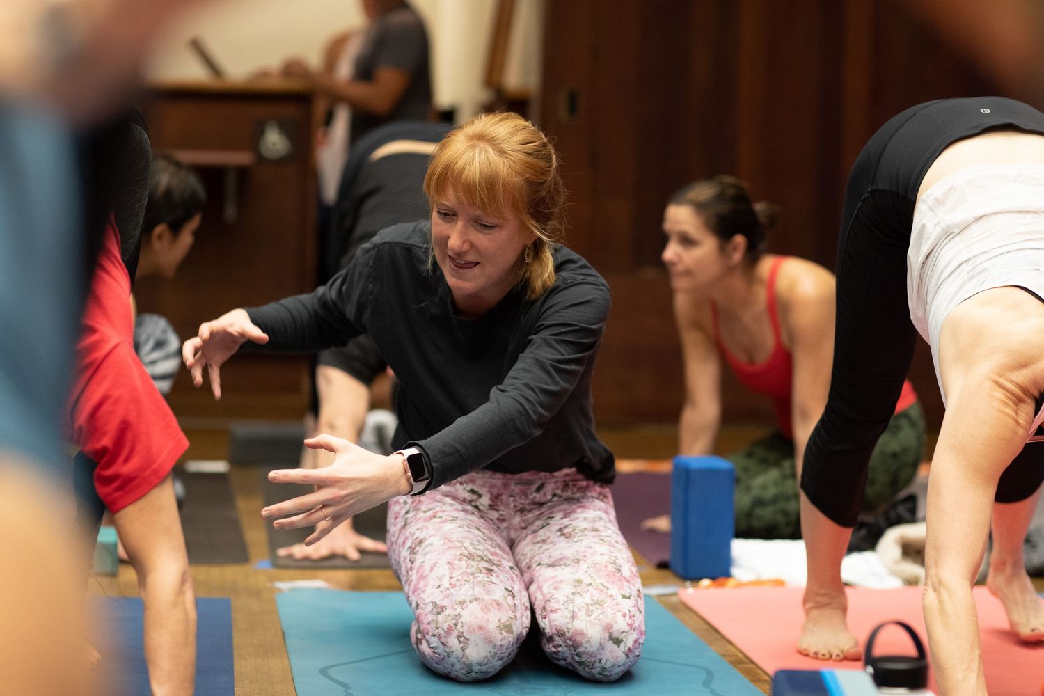 Participant practicing yoga pose on blue mat during indoor workshop.