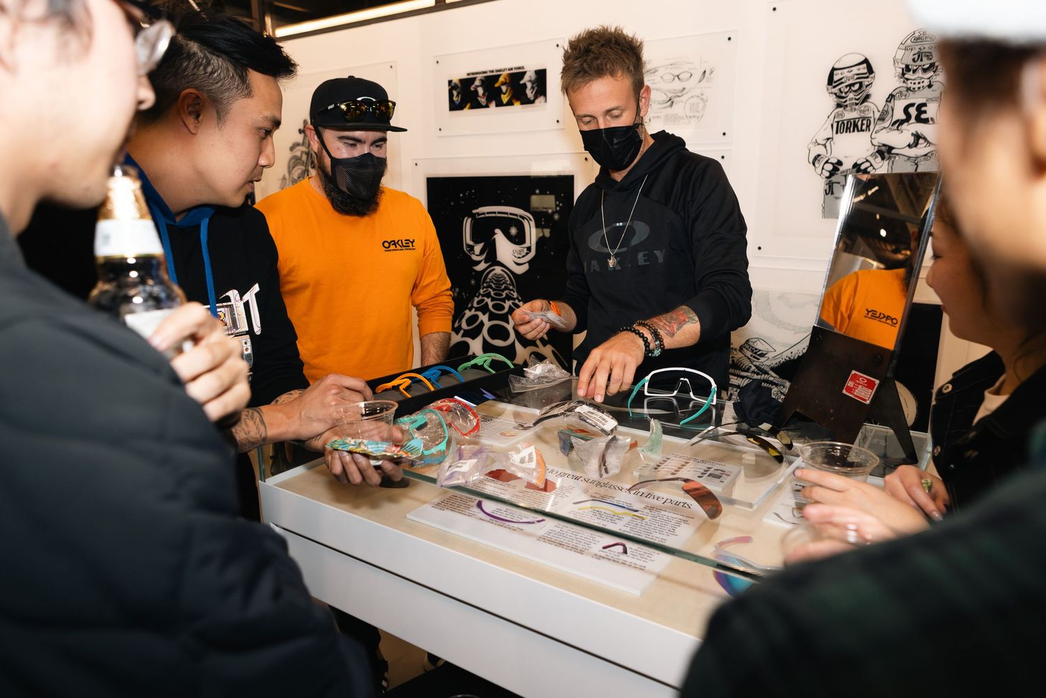 People gathered around a display table examining items at what appears to be a retail event.
