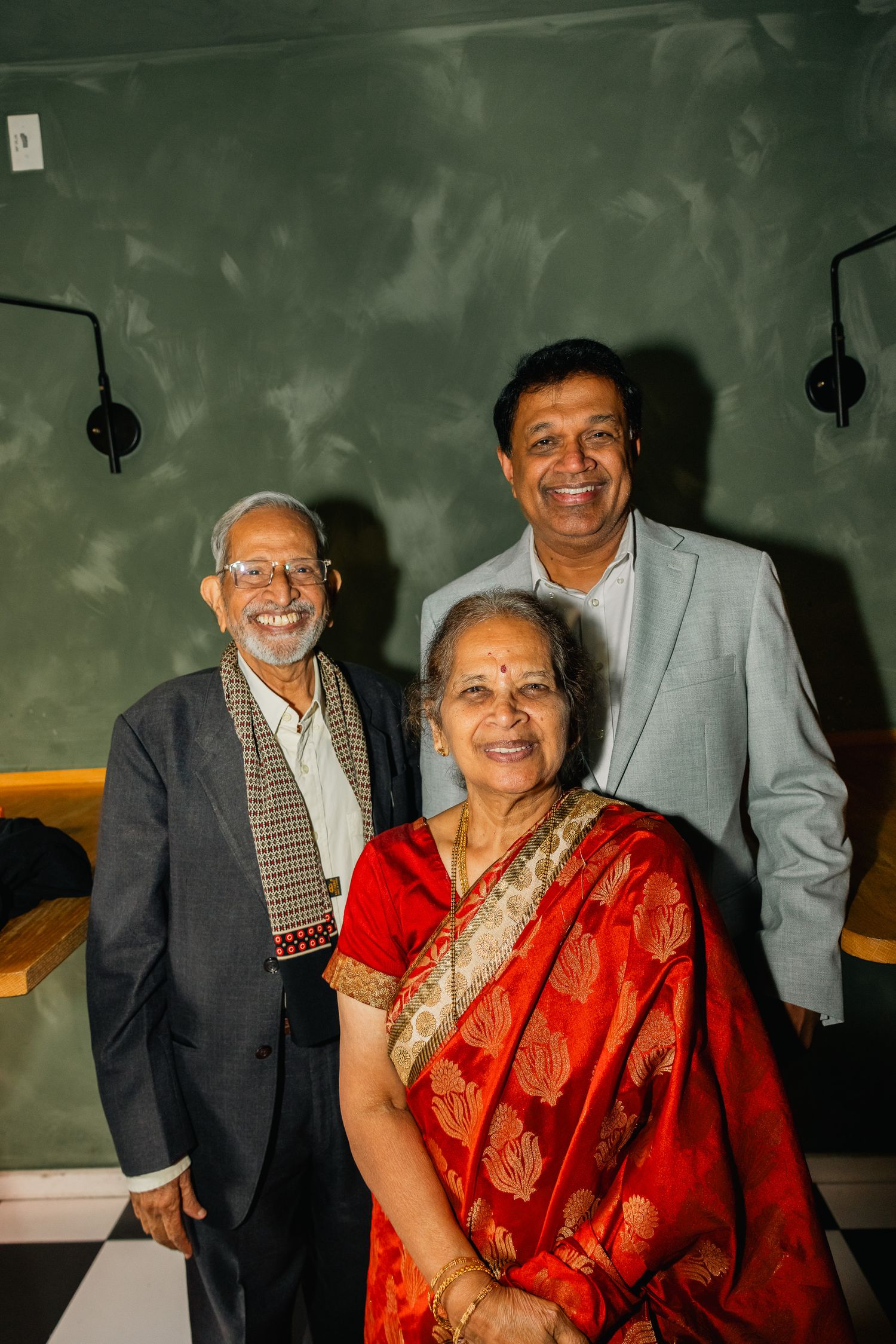 People wearing traditional Indian formal wear at a celebratory event.