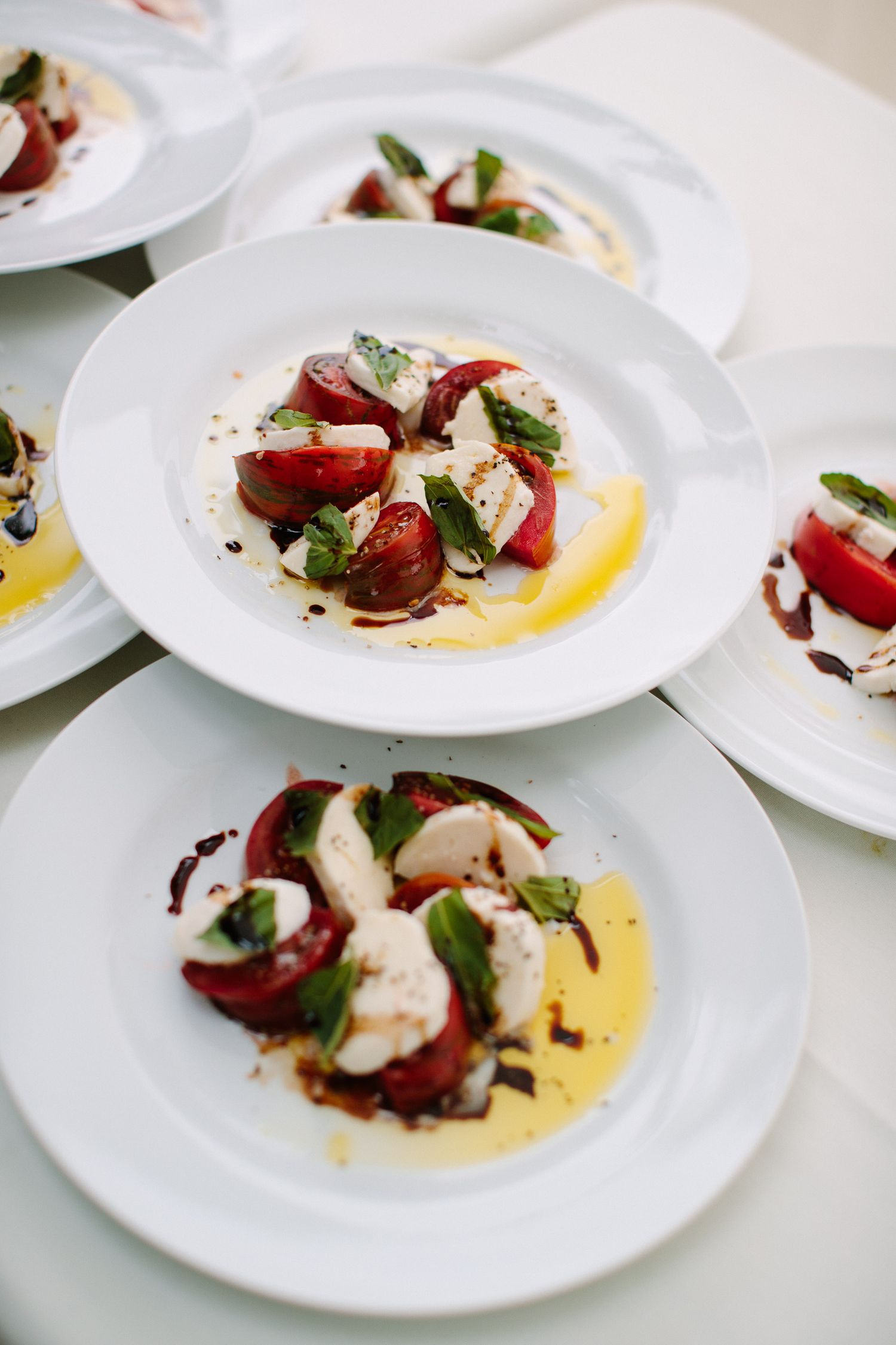 Elegant plated appetizers featuring red beets with creamy sauce and herbs on white dishes.