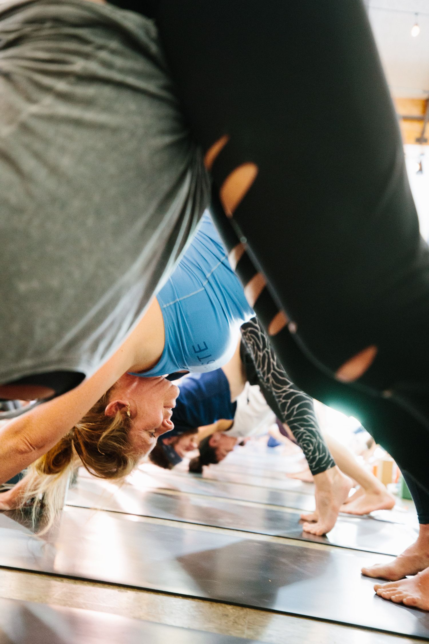 Yoga practitioners performing wall-assisted inversions during class.