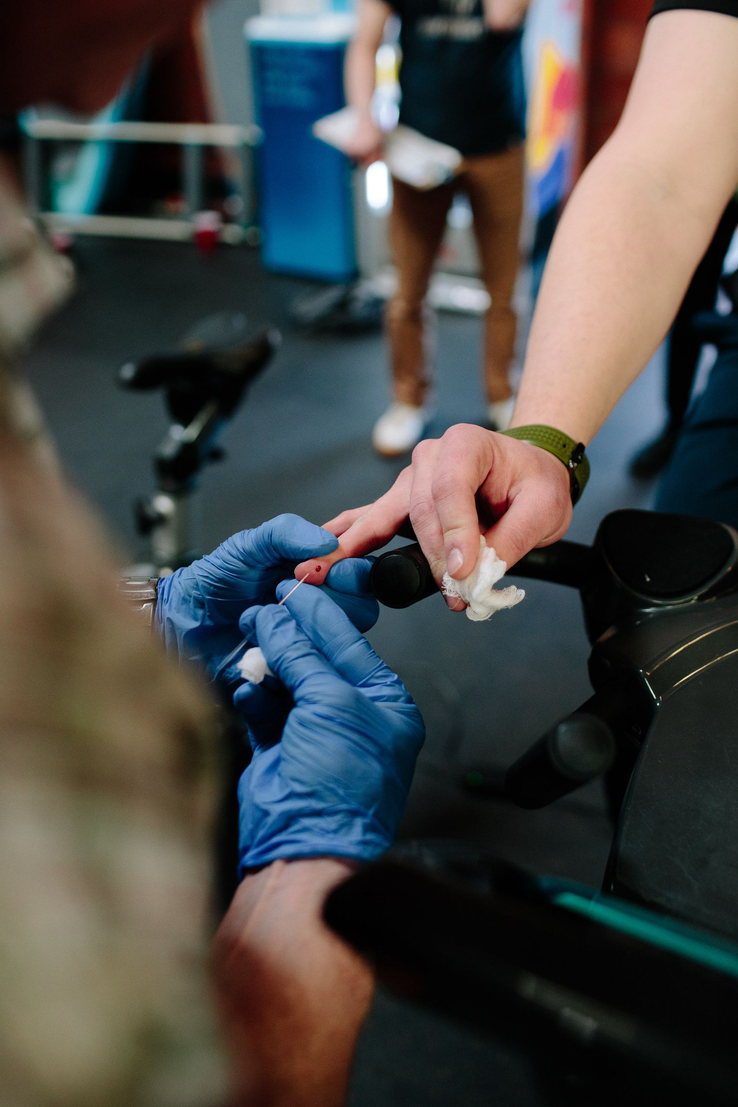 Close-up view of hands wearing blue medical gloves working with laptop keyboards and documents.