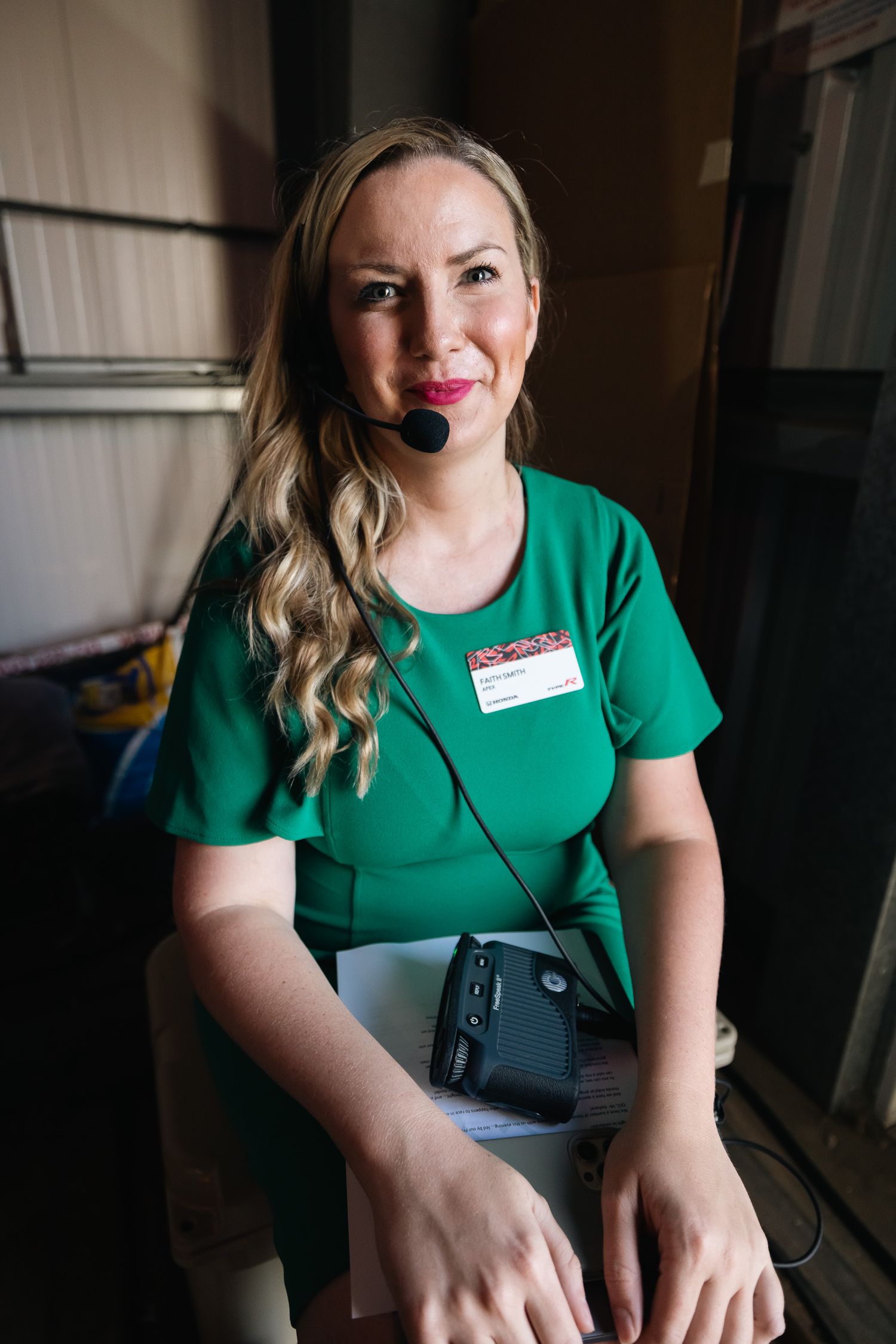 Person in green t-shirt operating equipment at a professional event.
