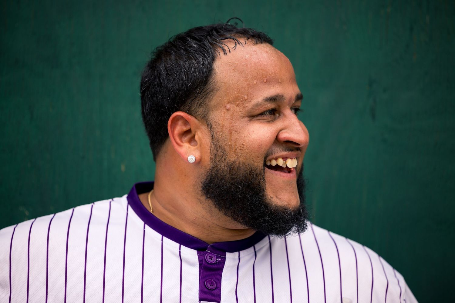 A collage of six baseball players in white pinstriped uniforms smiling and laughing together against a green background.