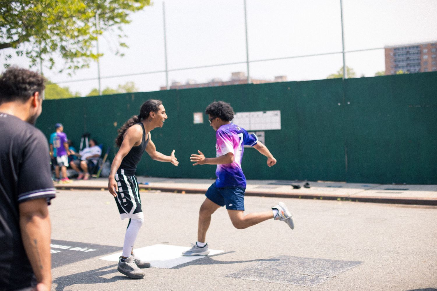 Group of basketball players in action on an outdoor court, showing multiple plays in different frames of movement.