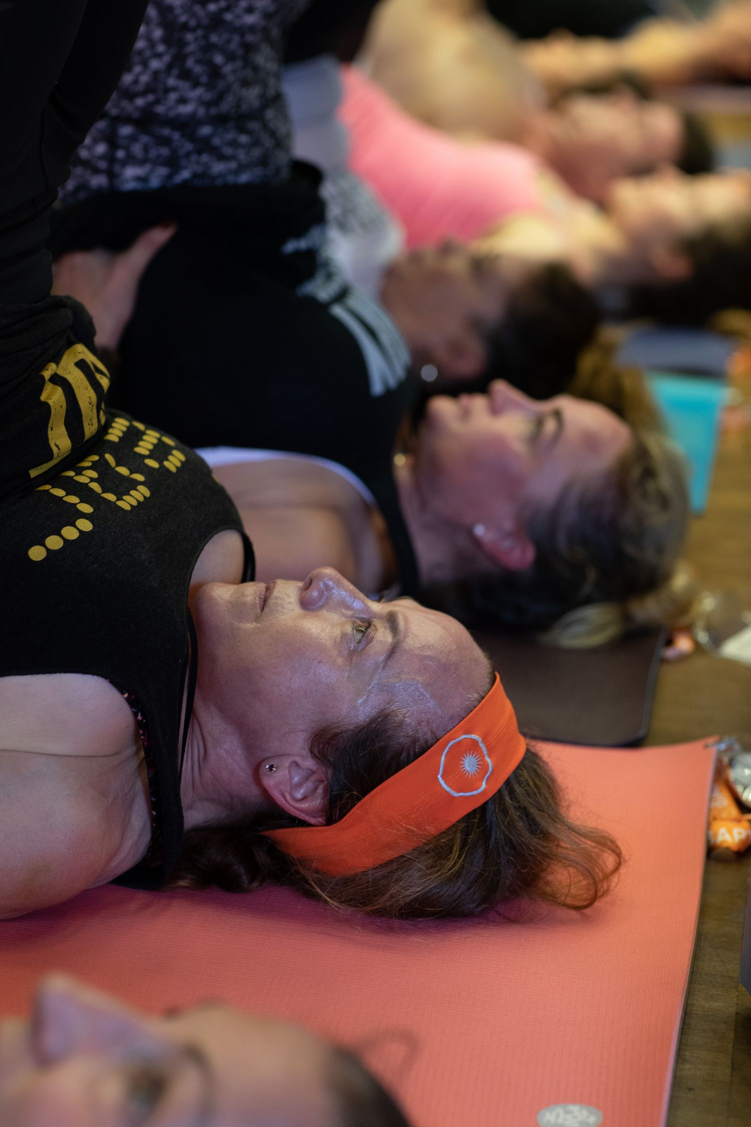 Group of participants lying down on exercise mats during a wellness or relaxation session.