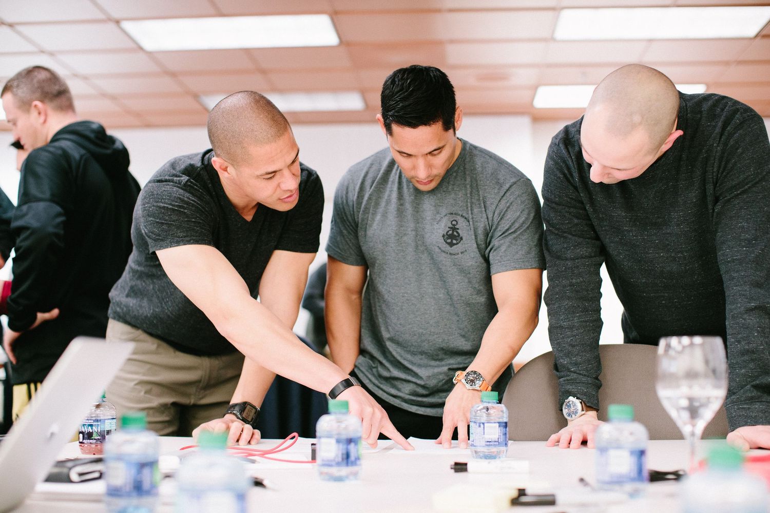 Group of students leaning over a table examining objects during a workshop.