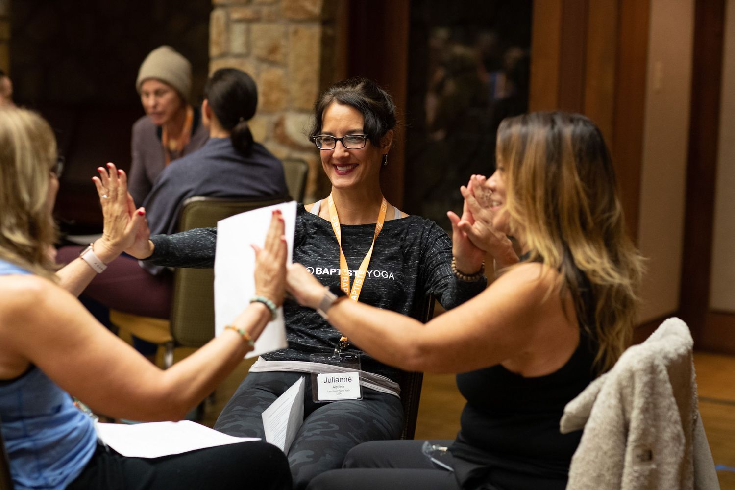 Workshop participants practicing partner exercises and high-fives during an interactive session.