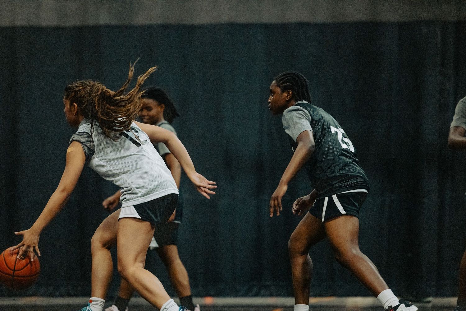 Players engaged in defensive drills during basketball practice session.