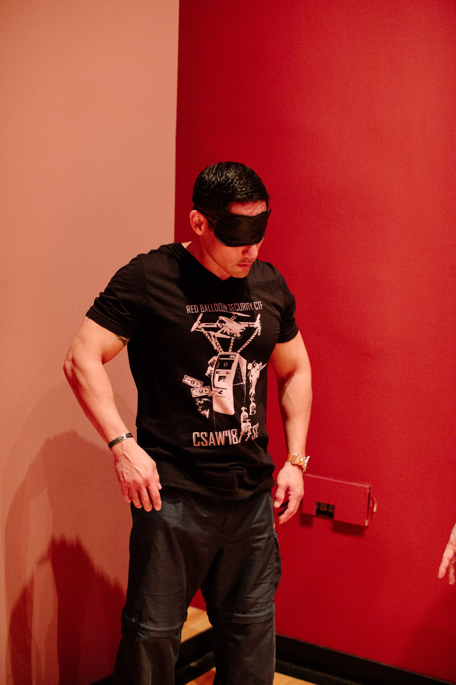 Person demonstrating movement against red wall during training or performance session.