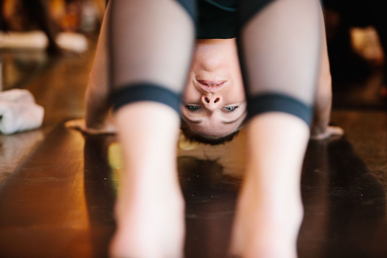 Close-up view of exercise participants on dark fitness mats during a class.