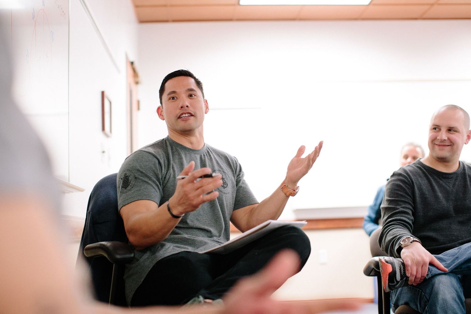 Multiple participants engaged in discussion during an indoor training session.