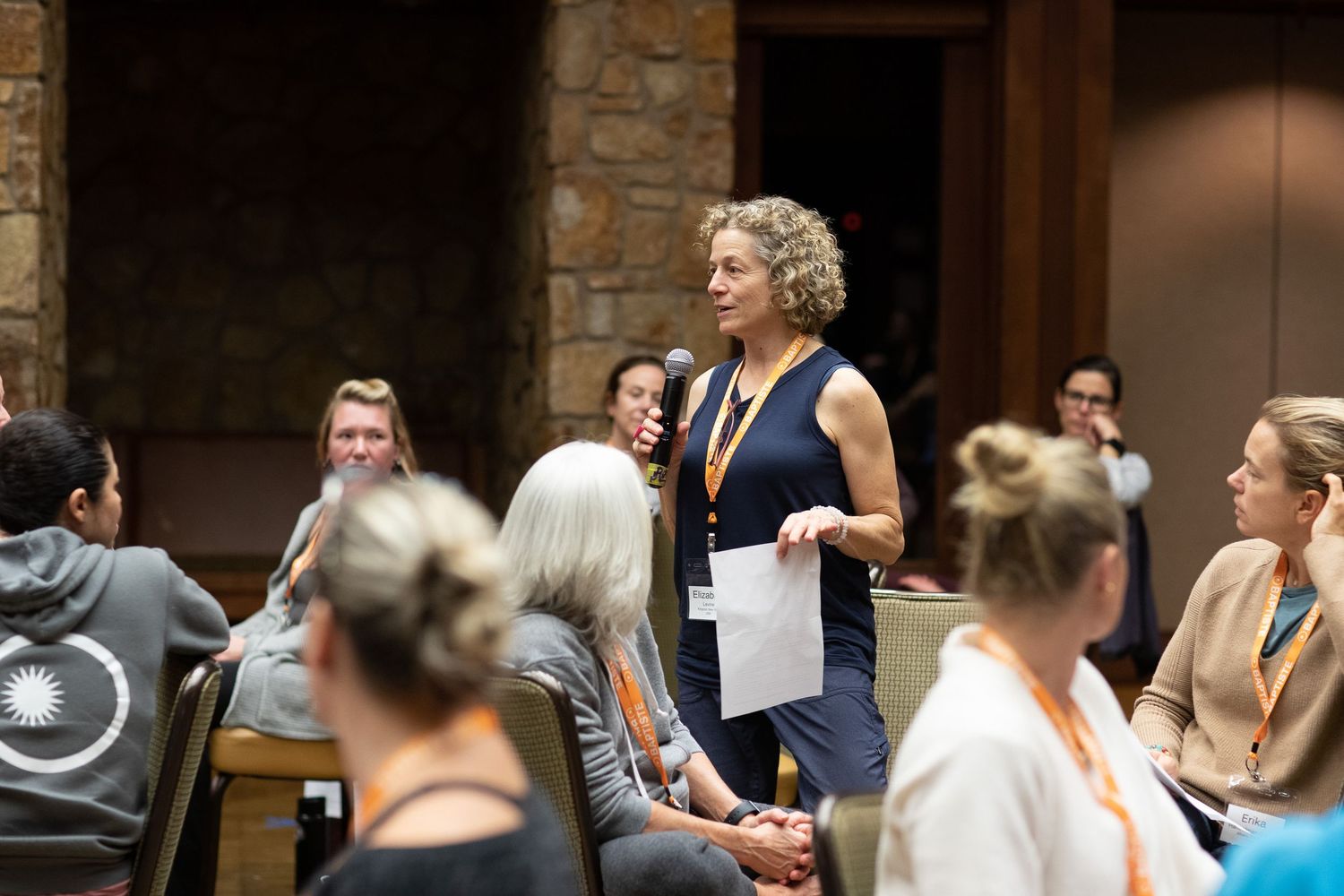Conference attendees participate in an interactive group workshop session in a stone-walled venue.