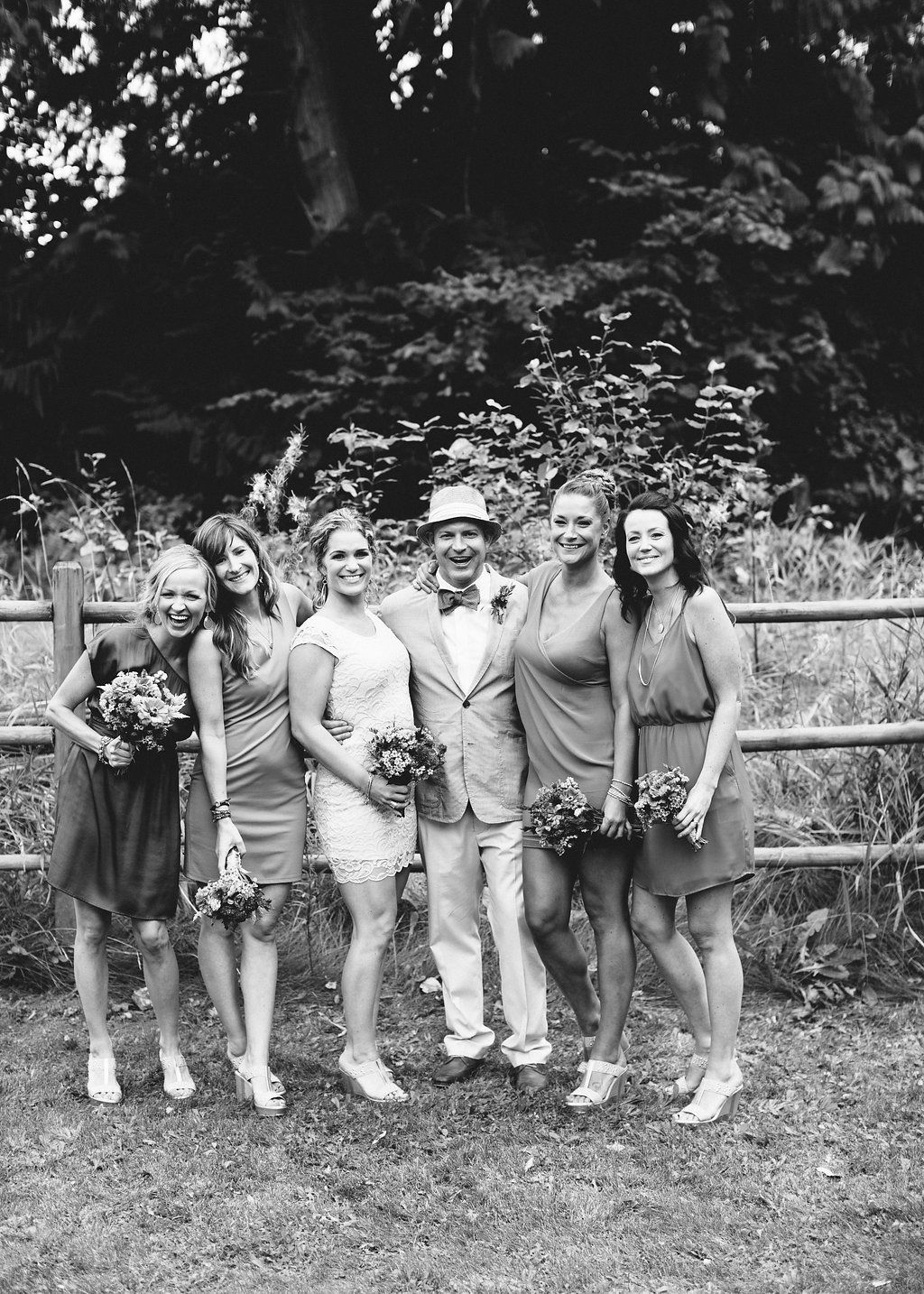A group of people sitting casually on a wooden fence in a park setting, shown in a sequence of similar poses.