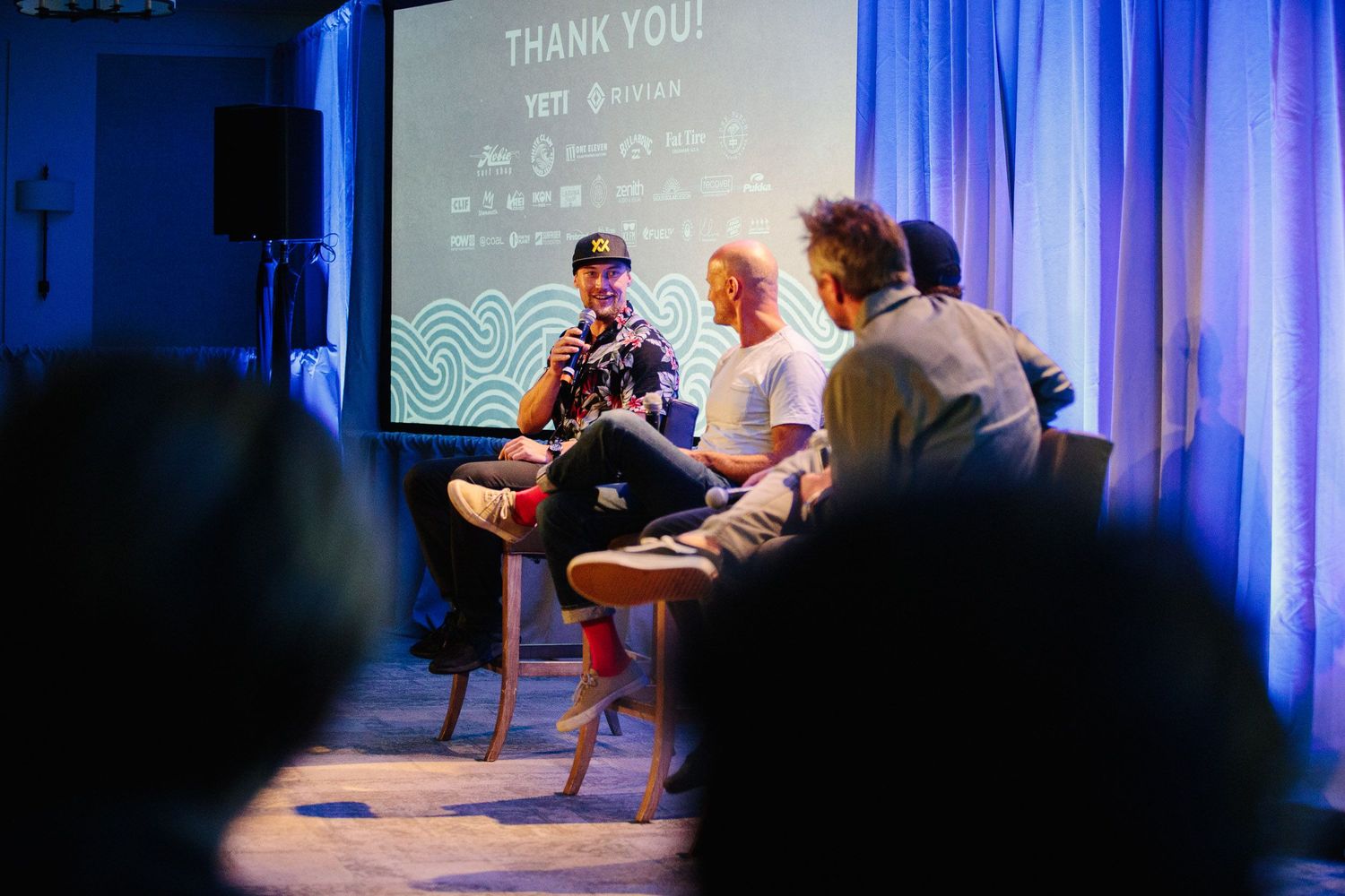 Conference presentation stage with blue lighting and 'Thank You' displayed on screen.